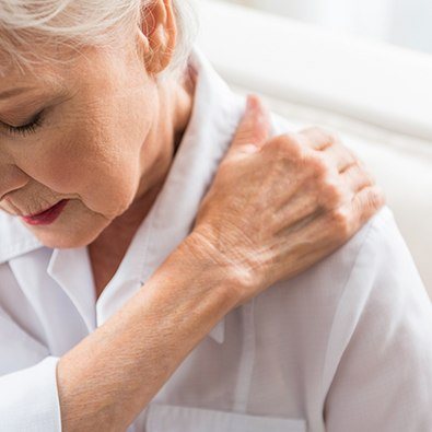 Older woman with shoulder arthritis holding arm