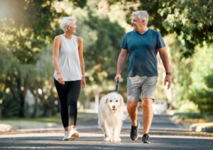 Older couple walking their dog