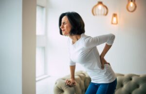 Woman struggling to stand up, dealing with back pain