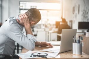 Man sitting at desk, suffering from neck pain